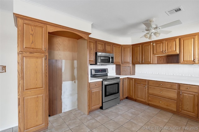 kitchen with ceiling fan, appliances with stainless steel finishes, decorative backsplash, and light tile patterned floors