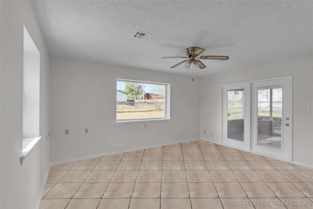 tiled spare room featuring ceiling fan and a textured ceiling