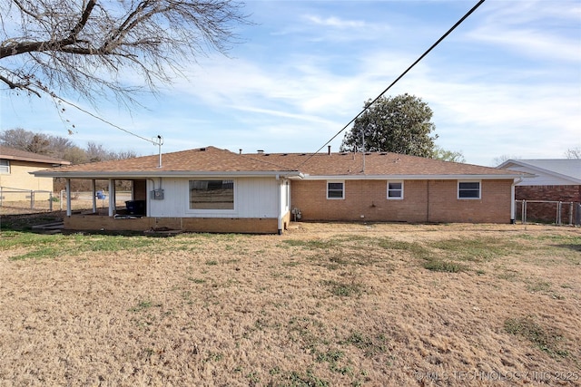 rear view of property featuring a yard