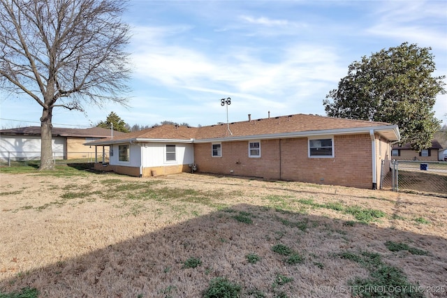 rear view of house featuring a lawn