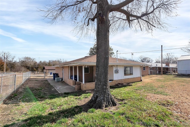 rear view of house with a patio and a lawn