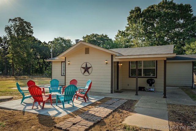 back of property featuring a patio area and an outdoor fire pit