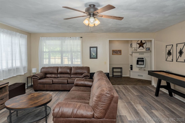 living room with hardwood / wood-style flooring, heating unit, a textured ceiling, and ceiling fan