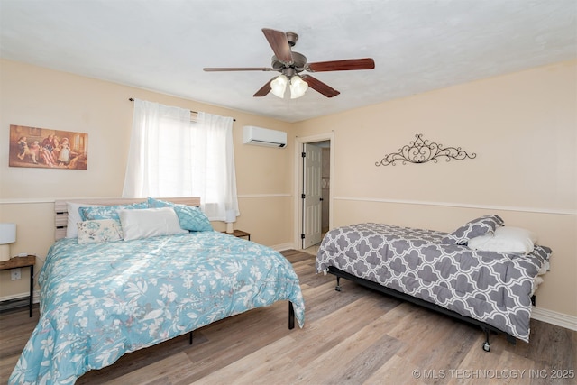 bedroom featuring an AC wall unit, hardwood / wood-style floors, and ceiling fan