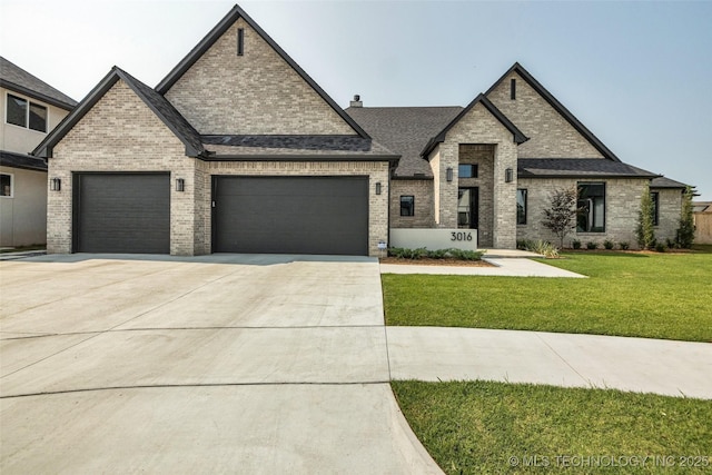 french country style house featuring a garage and a front lawn