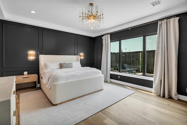 bedroom with a chandelier and light hardwood / wood-style flooring