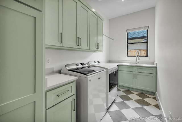 washroom with cabinets, separate washer and dryer, and sink