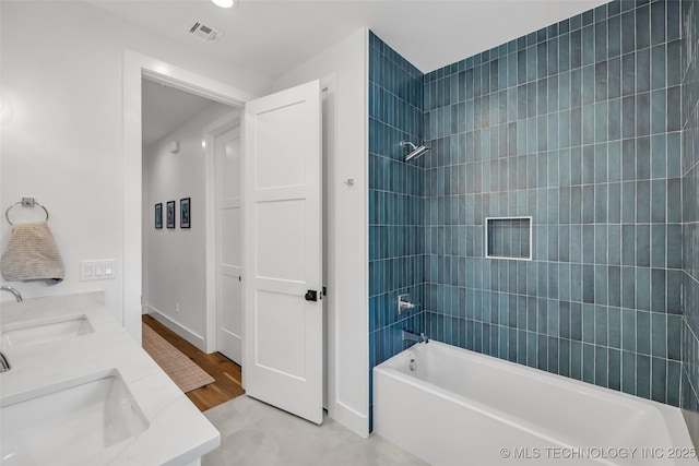 bathroom with vanity, tiled shower / bath combo, and hardwood / wood-style floors