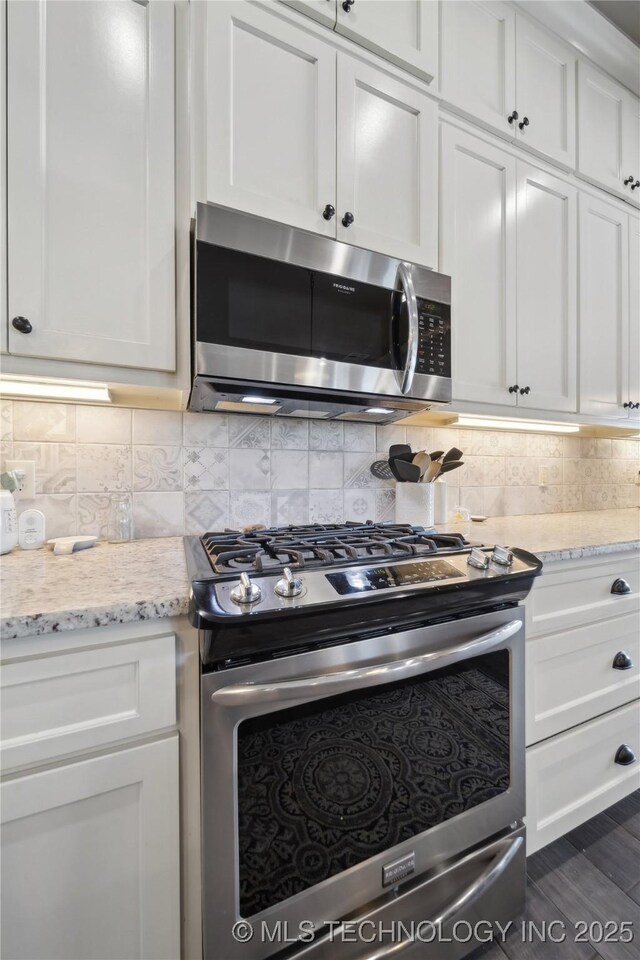 kitchen featuring white cabinetry, light stone countertops, and stainless steel appliances