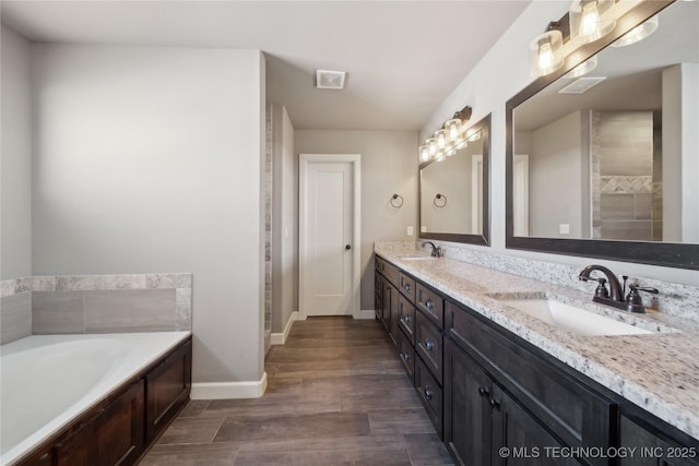 bathroom featuring vanity, hardwood / wood-style floors, and a washtub