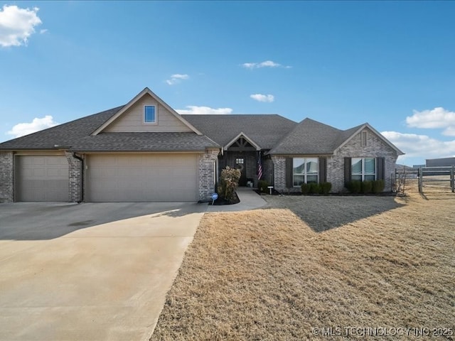 view of front of home featuring an attached garage, a shingled roof, concrete driveway, and brick siding