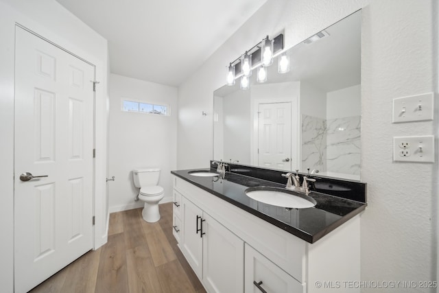 bathroom featuring wood-type flooring, vanity, and toilet