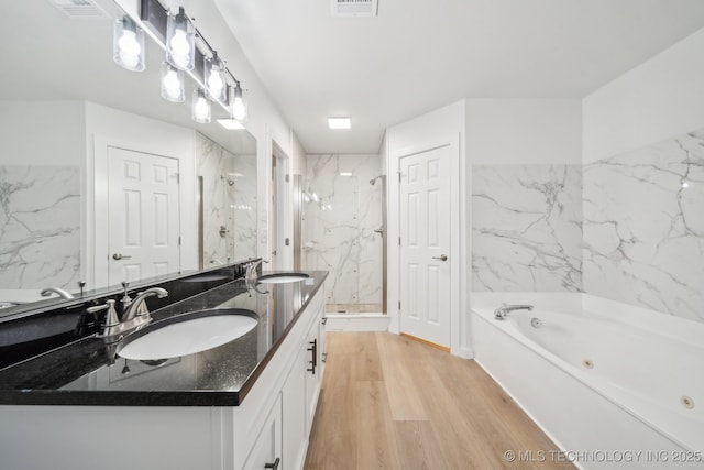 bathroom featuring independent shower and bath, wood-type flooring, and vanity