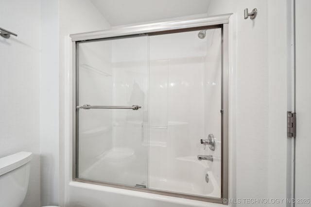 bathroom with shower / bath combination with glass door and toilet