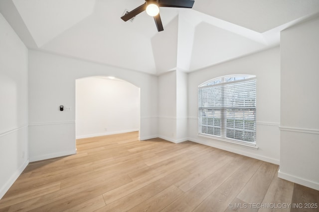 empty room featuring ceiling fan, high vaulted ceiling, and light wood-type flooring