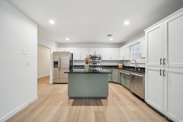 kitchen with sink, white cabinetry, appliances with stainless steel finishes, green cabinets, and light hardwood / wood-style floors