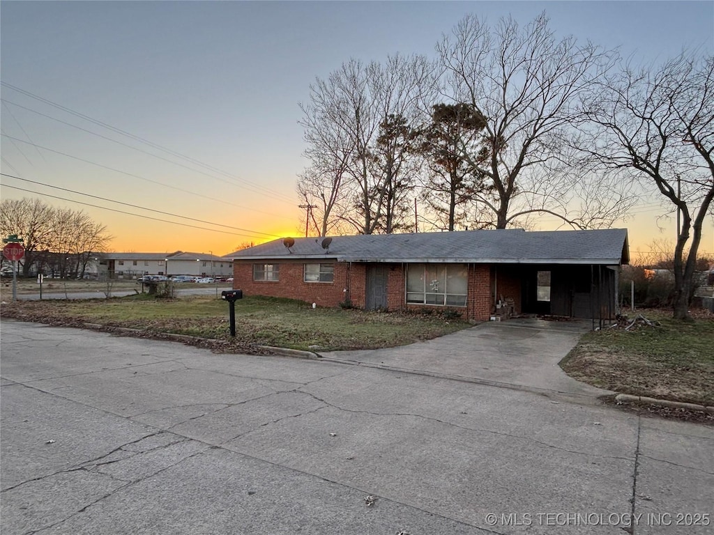 view of front of property featuring a carport and a lawn