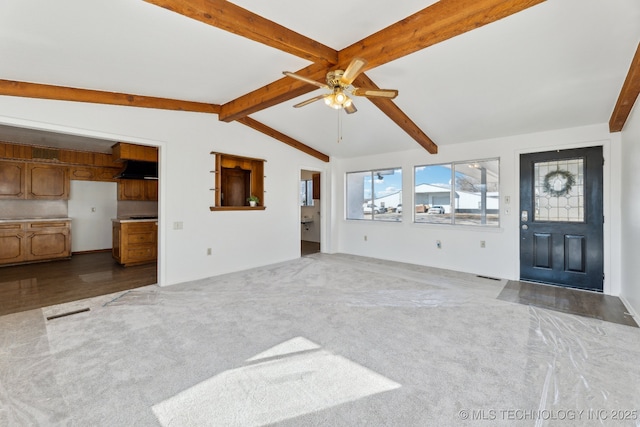 unfurnished living room featuring vaulted ceiling with beams, carpet flooring, and a ceiling fan