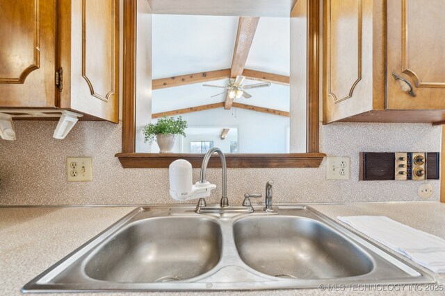 10541 Sahoma Lake Rd, Sapulpa, OK 74066 - kitchen with light countertops, decorative backsplash, a ceiling fan, brown cabinetry, and beamed ceiling
