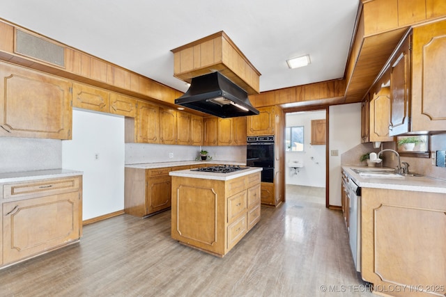 kitchen with light countertops, a sink, dobule oven black, and island range hood