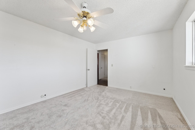 spare room featuring carpet flooring, ceiling fan, a textured ceiling, and baseboards