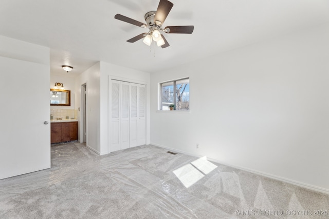 unfurnished bedroom with carpet floors, a closet, visible vents, and baseboards