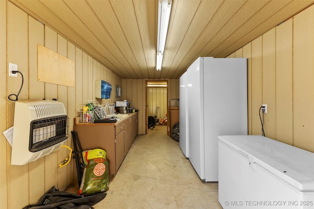 kitchen with heating unit, wood walls, refrigerator, wooden ceiling, and white fridge