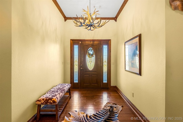 entryway with crown molding, plenty of natural light, dark hardwood / wood-style floors, and a notable chandelier