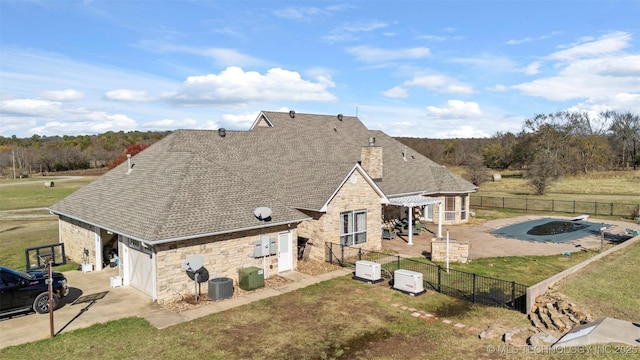 back of house featuring cooling unit, a patio, a lawn, and a pergola