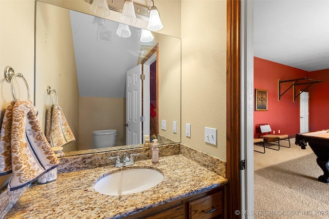 bathroom with vanity, vaulted ceiling, billiards, and toilet