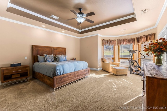 bedroom with ceiling fan, ornamental molding, a tray ceiling, and carpet