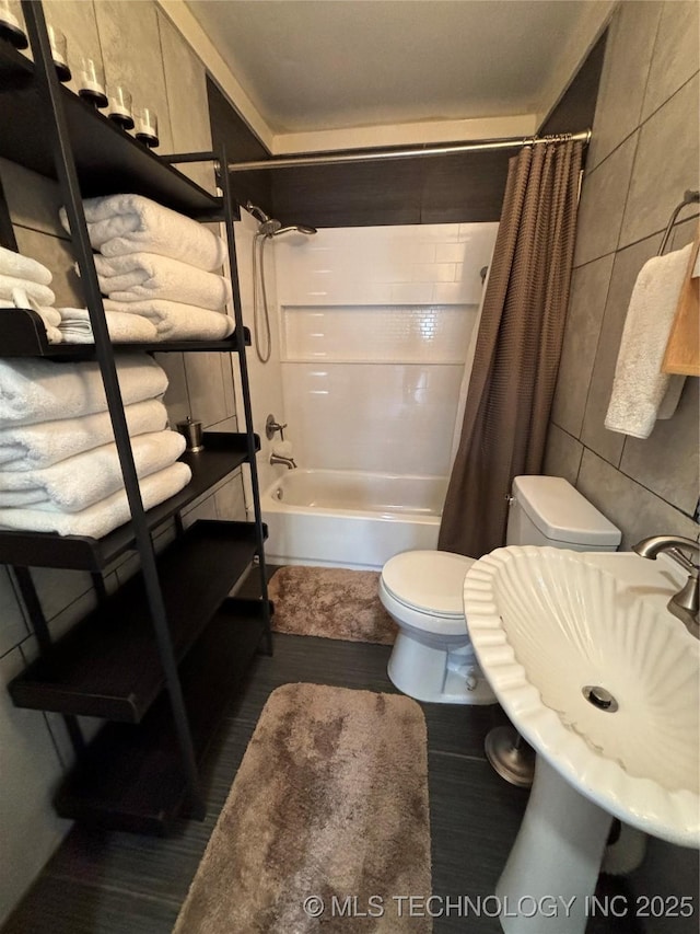 full bathroom with sink, tile walls, shower / tub combo, and toilet