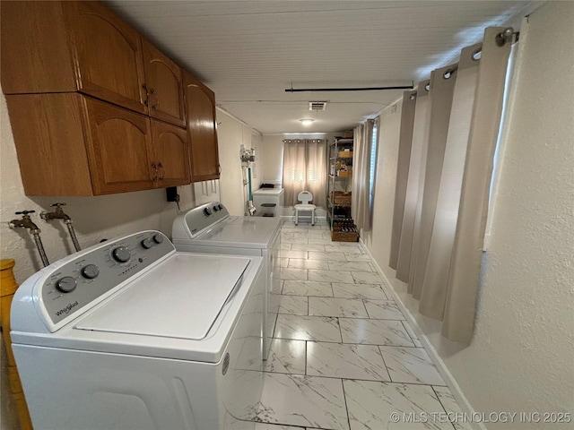 laundry room featuring cabinets and washing machine and dryer