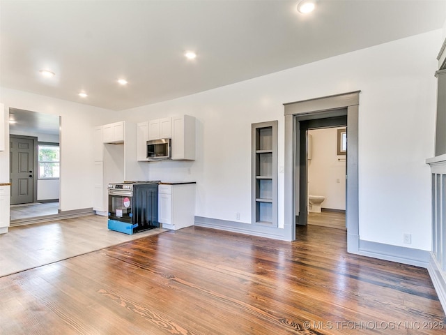 unfurnished living room with wood-type flooring and built in features