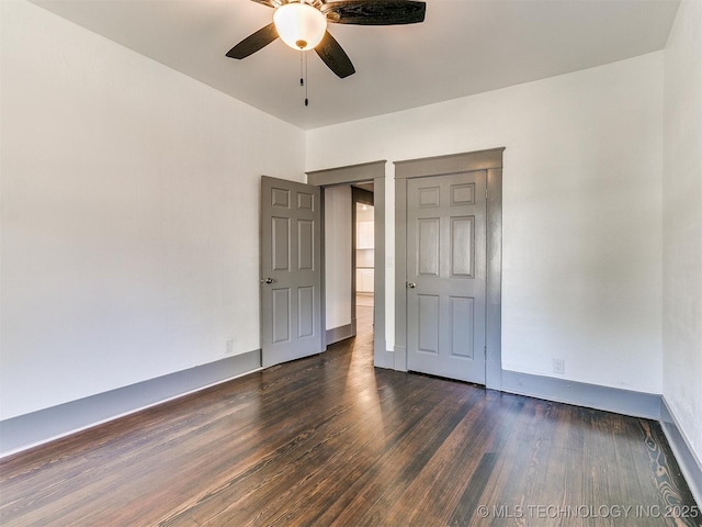 unfurnished bedroom with ceiling fan and dark hardwood / wood-style floors