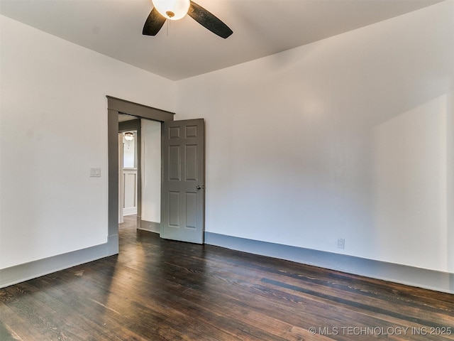 empty room with dark hardwood / wood-style floors and ceiling fan