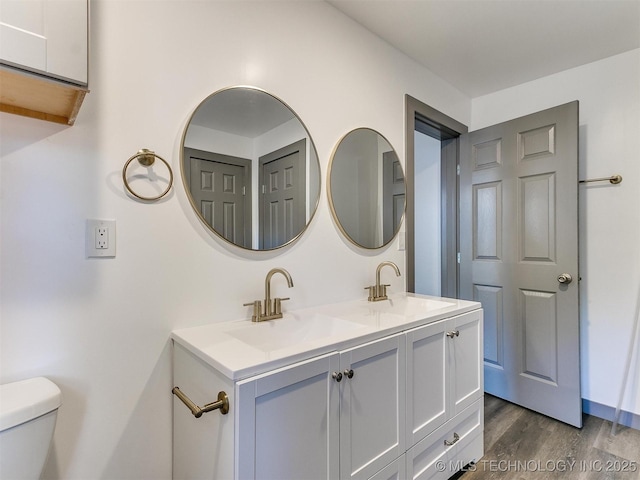 bathroom featuring wood-type flooring, vanity, and toilet