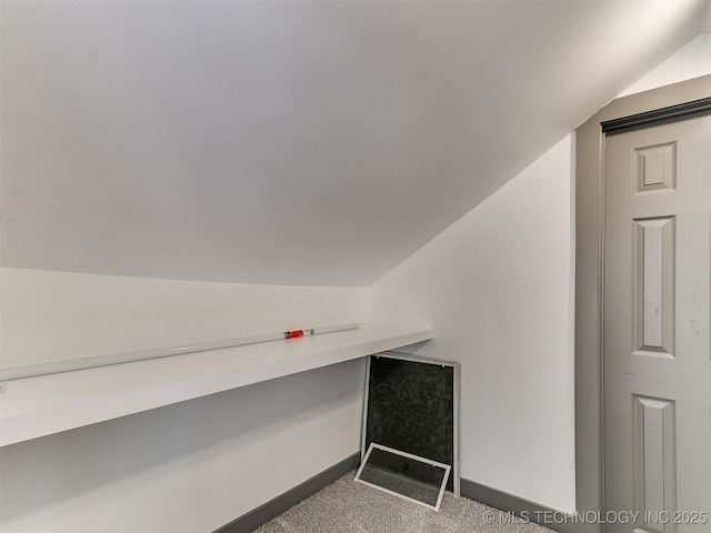 interior space featuring vaulted ceiling and carpet floors