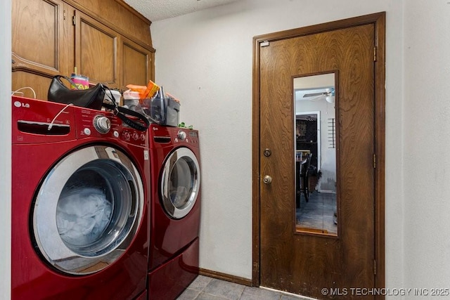 clothes washing area featuring cabinets, a textured ceiling, and washer and clothes dryer