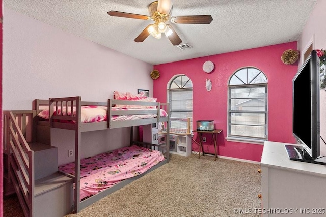 bedroom featuring a textured ceiling, ceiling fan, and carpet flooring