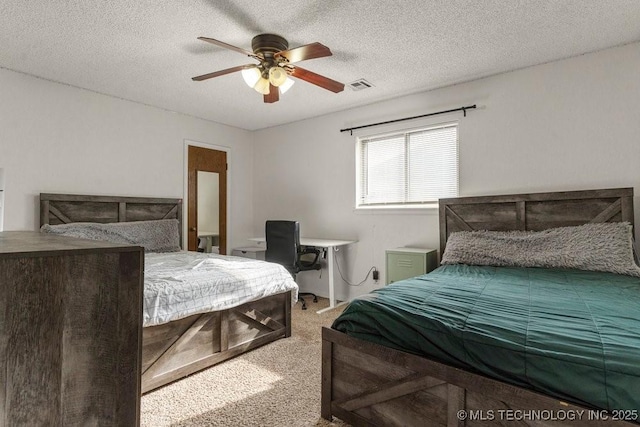 carpeted bedroom featuring a textured ceiling and ceiling fan