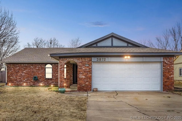 single story home featuring a garage and a lawn