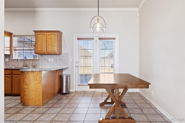 kitchen with sink, hanging light fixtures, ornamental molding, light tile patterned flooring, and decorative backsplash