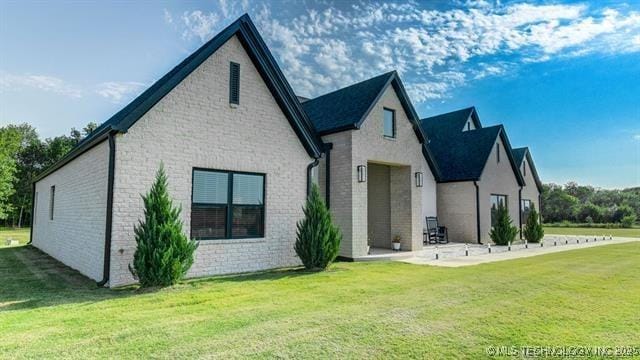 rear view of house with a yard and a patio