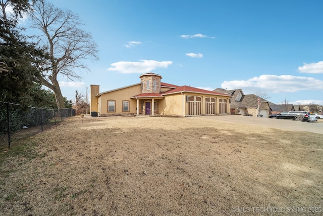 back of property featuring a garage and a lawn