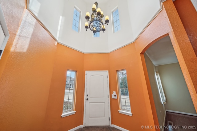 foyer featuring a towering ceiling and a notable chandelier