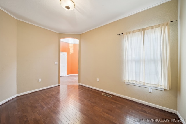 empty room with ornamental molding and wood-type flooring