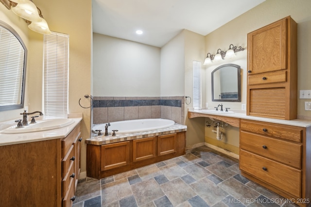 bathroom featuring a bath and double sink