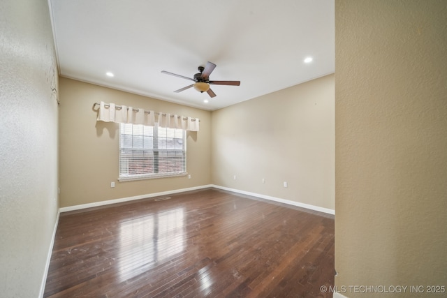 spare room with dark wood-type flooring and ceiling fan