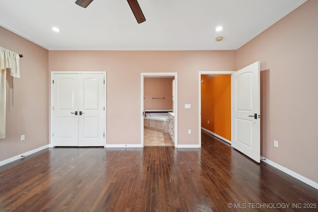 unfurnished bedroom featuring connected bathroom, ceiling fan, crown molding, dark wood-type flooring, and a closet